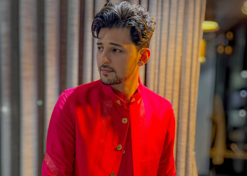 Darshan raval in red dress standing in a room